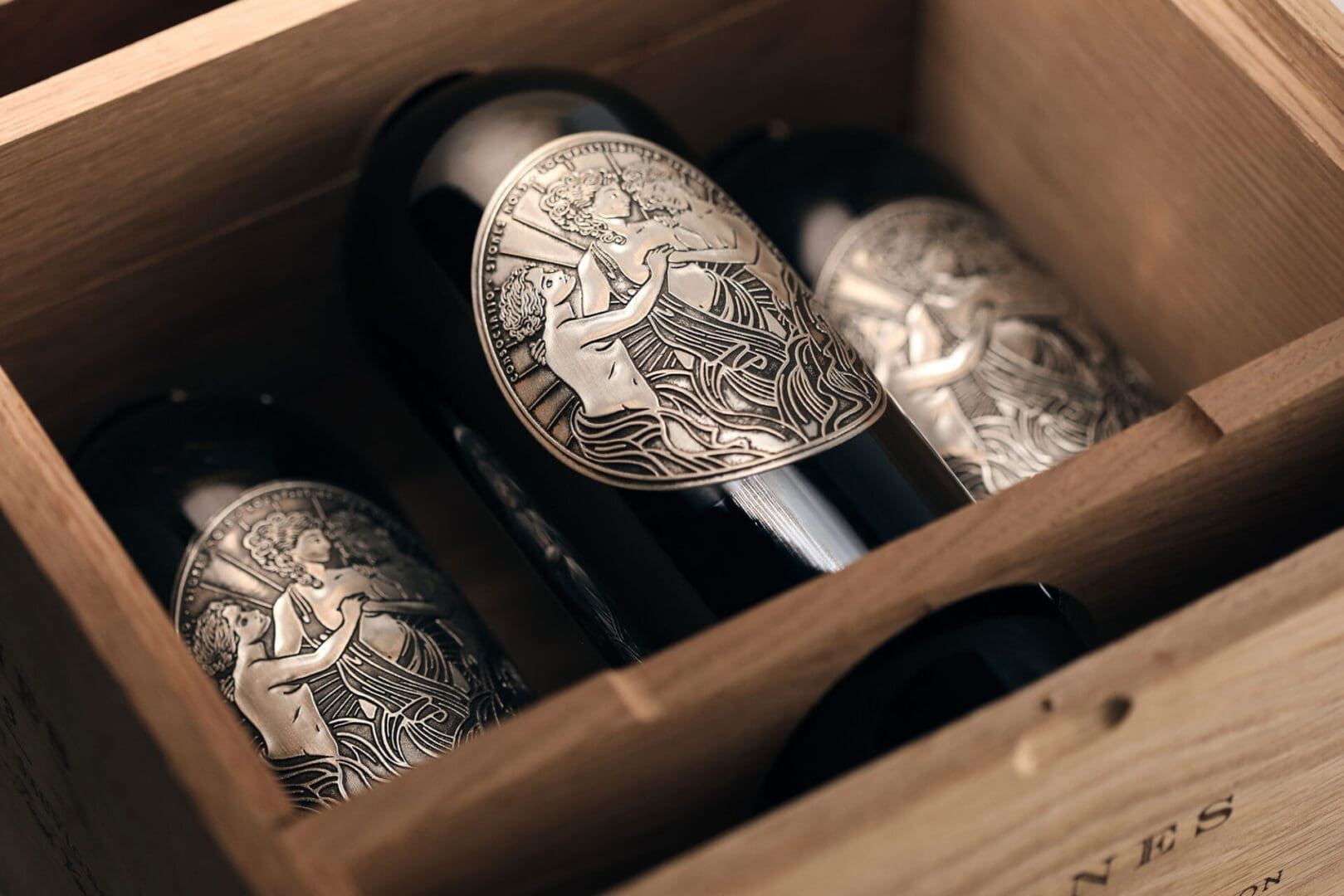 Wine bottles with ornate labels in box.